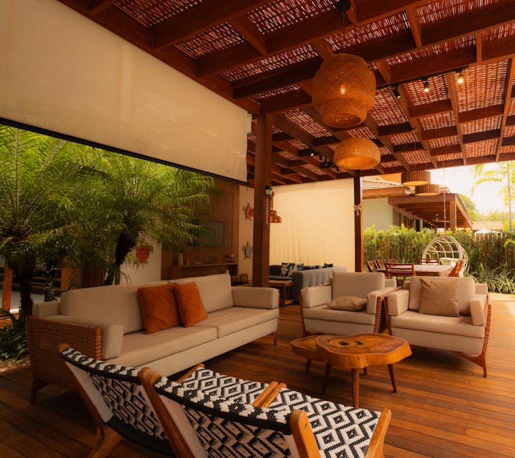 A stylish outdoor patio showcasing modern furniture and natural decor under a wooden pergola