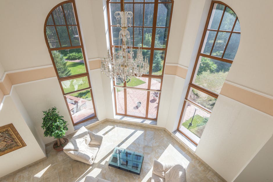 Spacious living area with floor-to-ceiling windows, elegant seating, and a grand chandelier